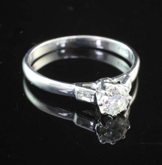 An 18ct white gold and single stone diamond ring with baguette cut diamond set shoulders, size P.